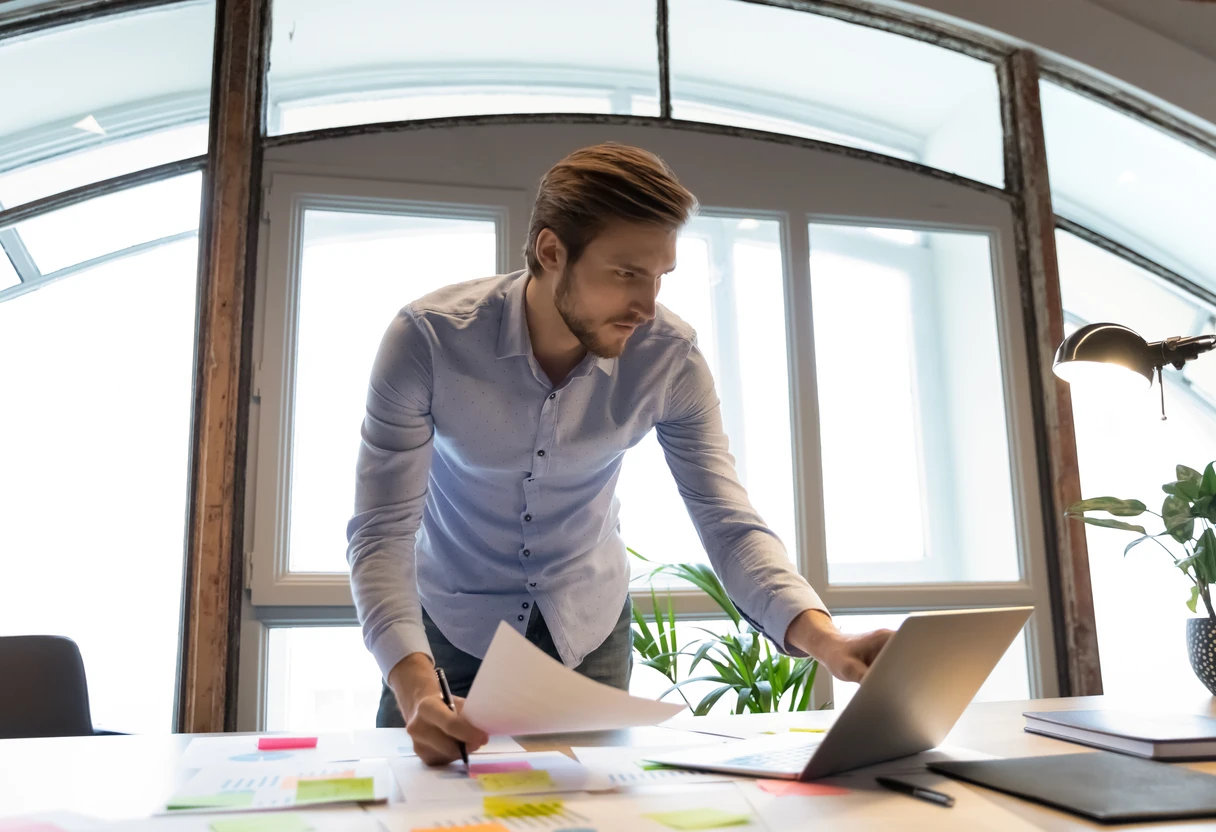 IT professional reviewing vendor documents at a standing desk